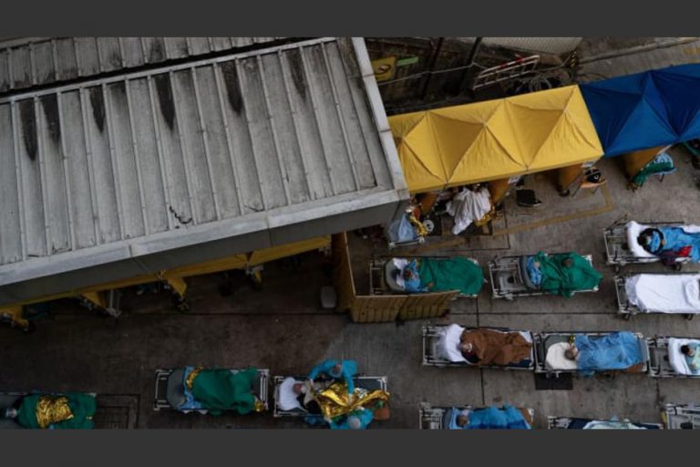 Pacientes esperan en camillas en las afueras de hospital en crisis por Covid en Hong